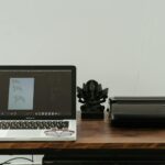 A creative home office setup featuring a laptop, printer, and artistic design work.