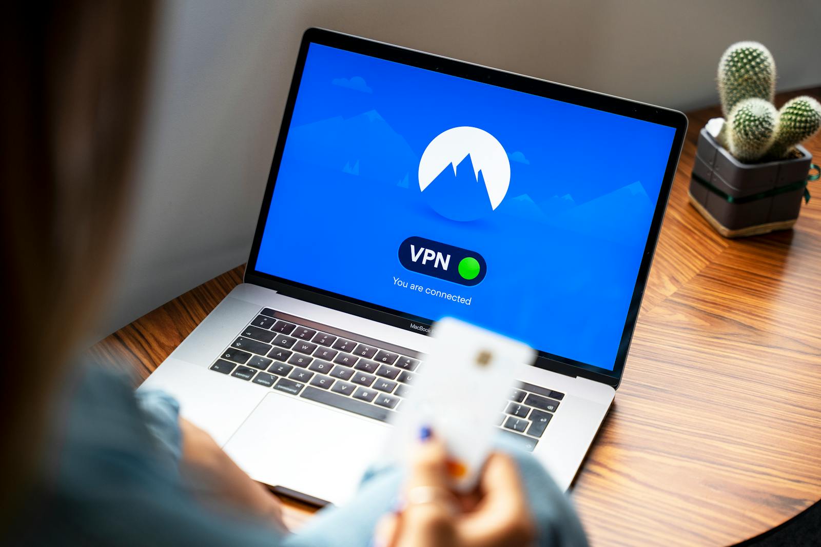 A person using a VPN on a laptop, symbolizing secure internet browsing in a modern indoor setting.