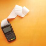 a cell phone sitting on top of a table next to a roll of paper